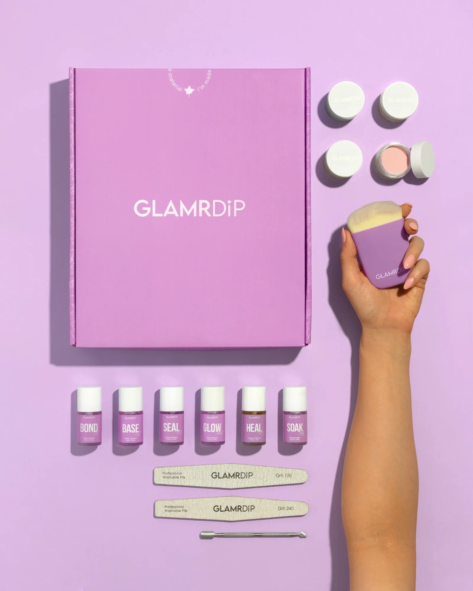 GLAMRDiP Salon Kit flatlay – lilla gaveeske, 6 flasker neglevæske, krukker med dippepudder, neglefiler, sminkekost og neglebåndsskyver